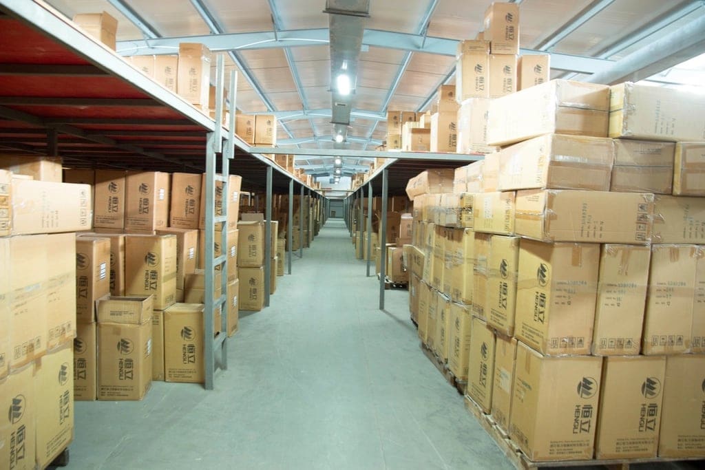 A warehouse aisle stacked with cardboard boxes.